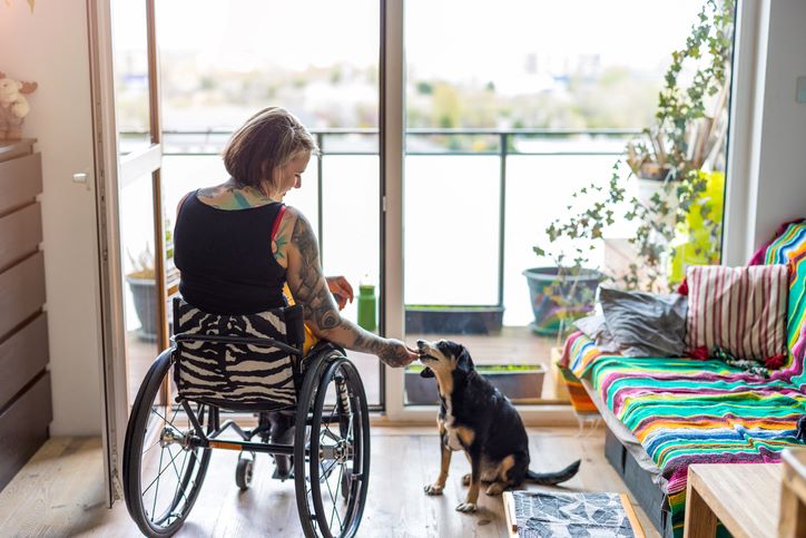 Young woman with disability with her dog at home